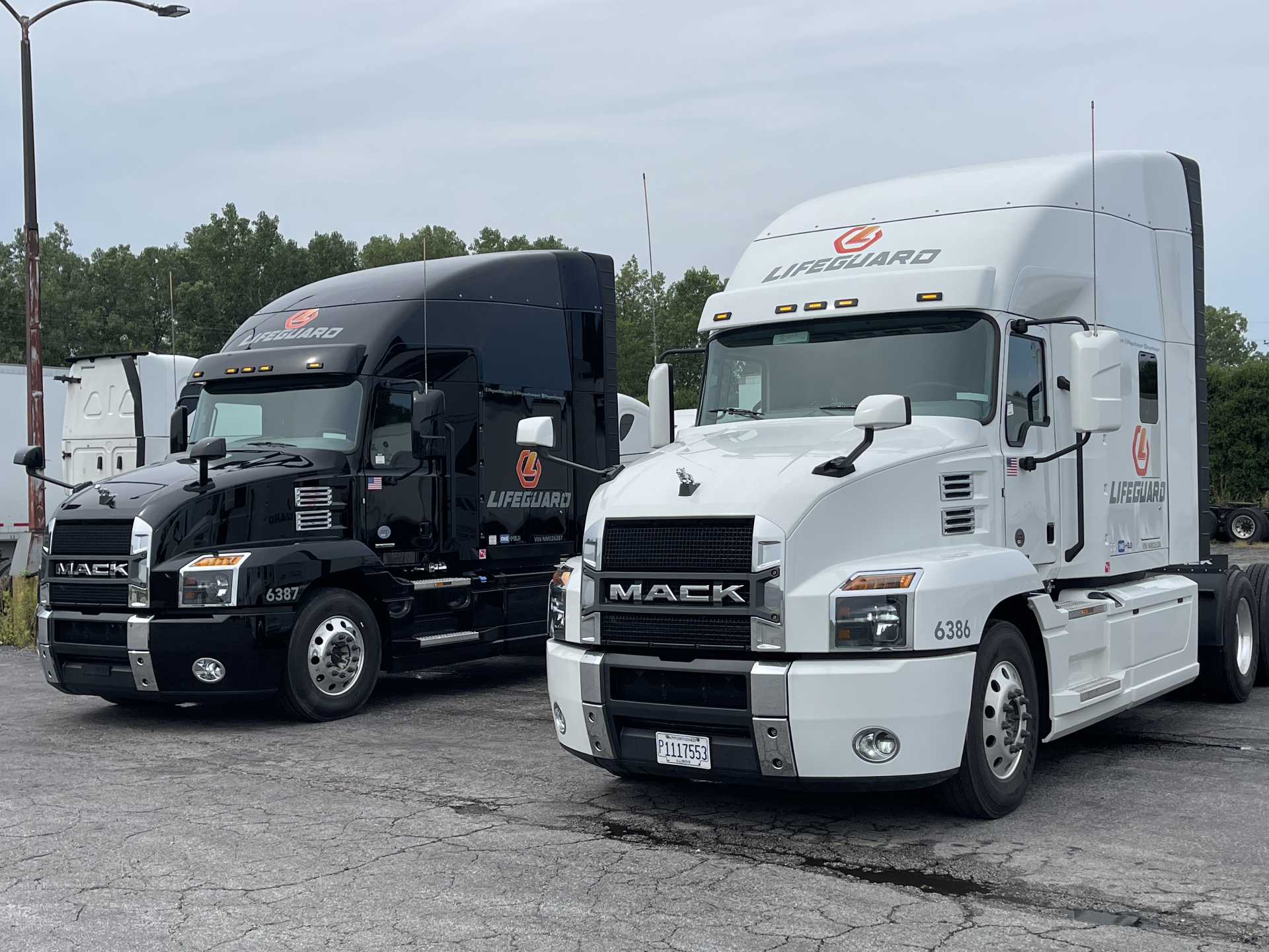 Black and white Mack Anthem tractors parked side by side