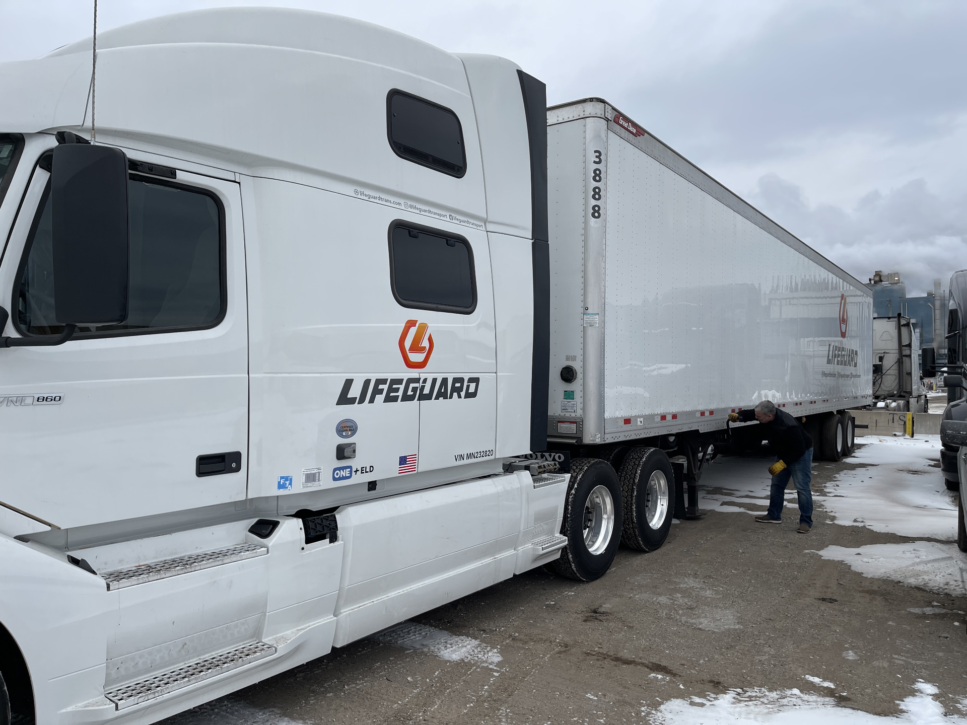 Driver hooking up a Volvo VNL 860 to a Lifeguard dry van trailer